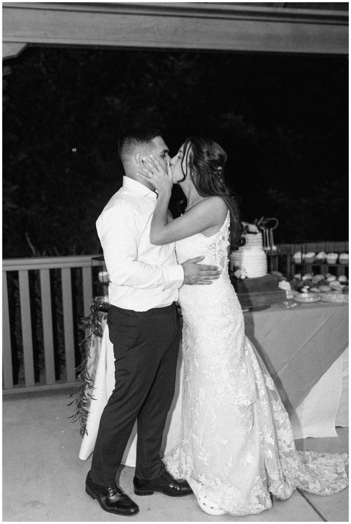 Bride and Groom kiss after cutting their wedding cake