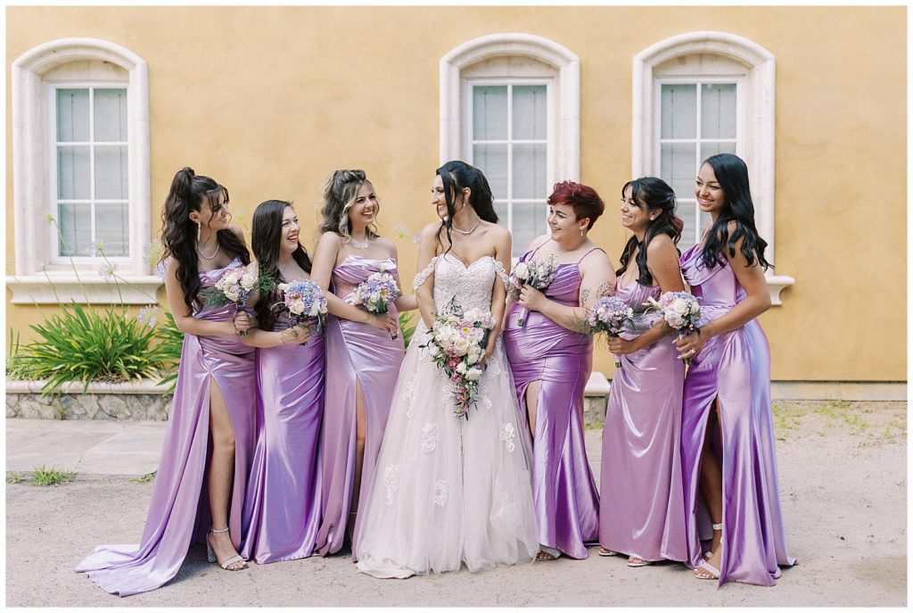 bride and her bridesmaids look at each other laughing
