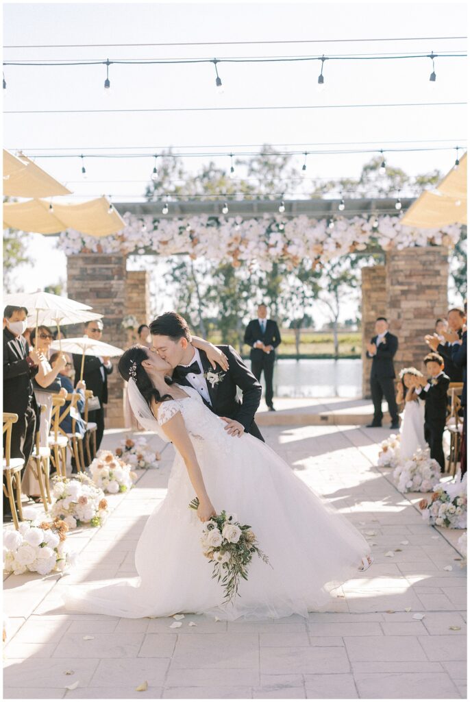 Groom dipping the bride and kissing her during their recessional.