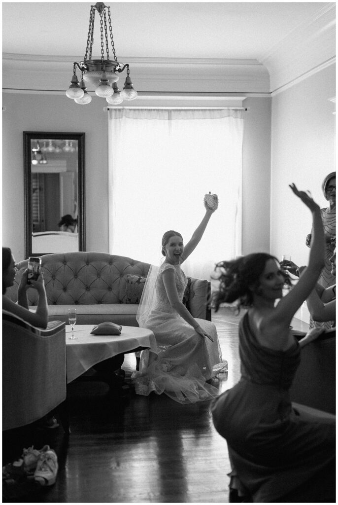 Black and white image of bride and her sister dancing in the getting-ready suite.