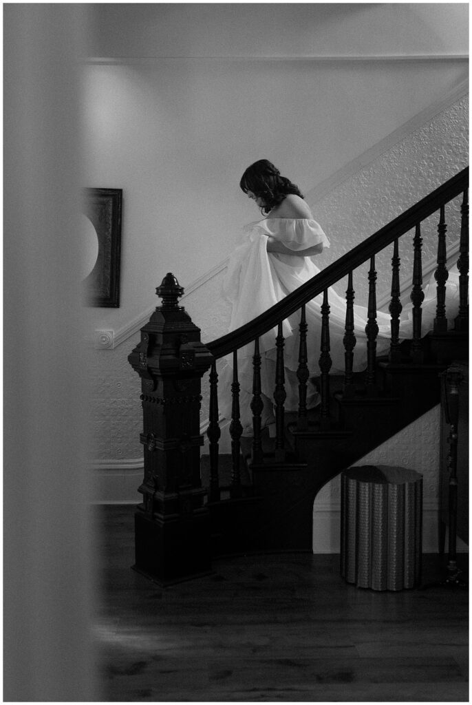 Black and white image of bride walking downstairs at Park Winters.