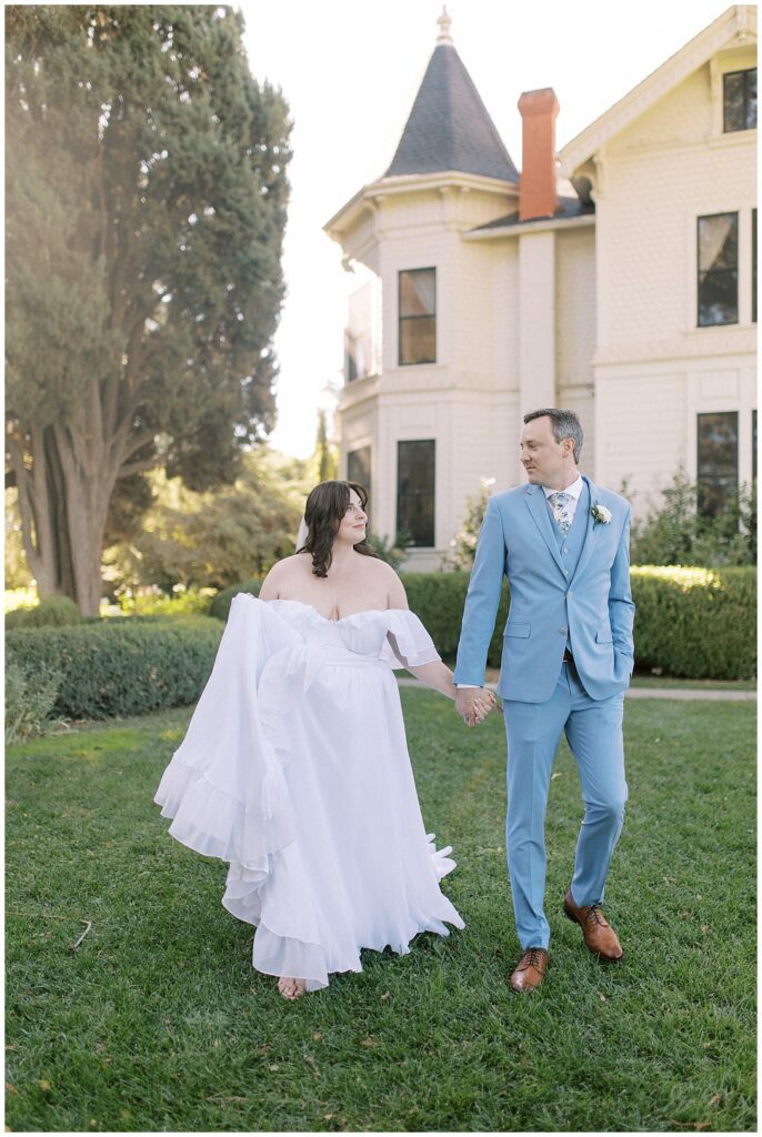 Bride and groom holding hands, walking in front of Park Winters.