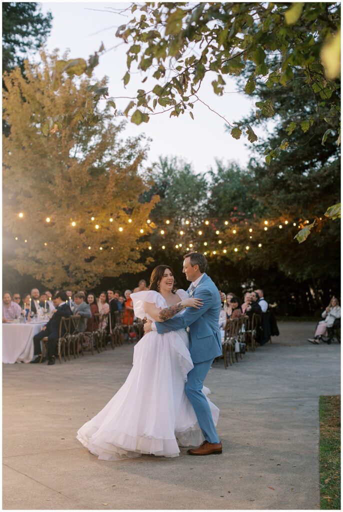 Bride and groom dancing with their loved ones in the background at Park Winters.