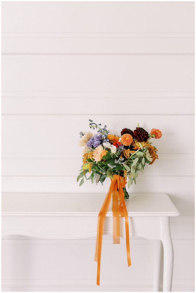 Bridal bouquet resting on top of a shelf.