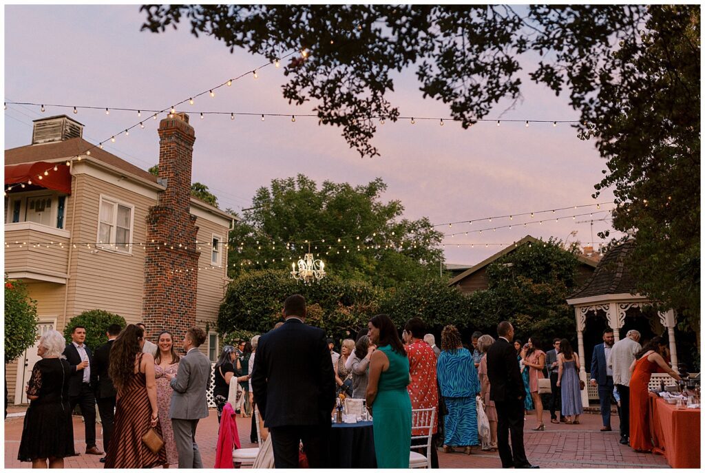 Guests mingling outside during the reception at dusk.